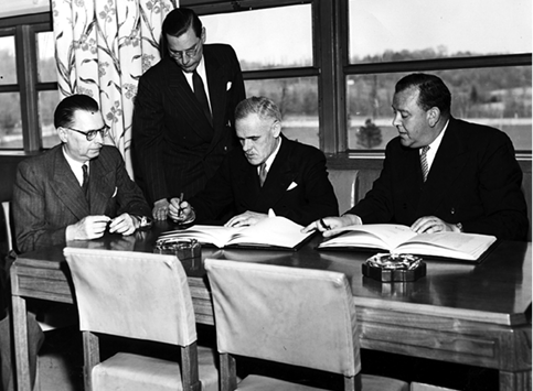 The Australian Ambassador to Paris and Representative at the United Nations, William R Hodgson (second right), signs without reservation the Constitution of the International Refugee Organization, New York, 13 May 1947. At the ceremony are UN Secretary-General Trygve Lie (right); Assistant Secretary-General of the UN Legal Department, Dr Ivan Kerno, Czechoslovakia (left); and Assistant Chief of the UN Protocol and Liaison Section, Pierre de Meulesmeester, Belgium (second left). [UN Photo]