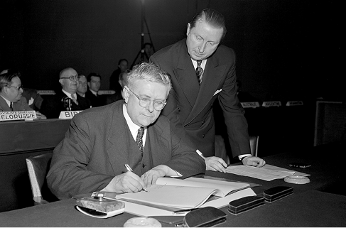 The Australian Minister for External Affairs and Attorney-General, and President of the UN General Assembly, Dr Herbert V Evatt, signs the Convention on the Prevention and Punishment of the Crime of Genocide, watched by the Chief of Protocol, Jehan de Noue, Paris, 11 December 1948. [UN Photo/MB]