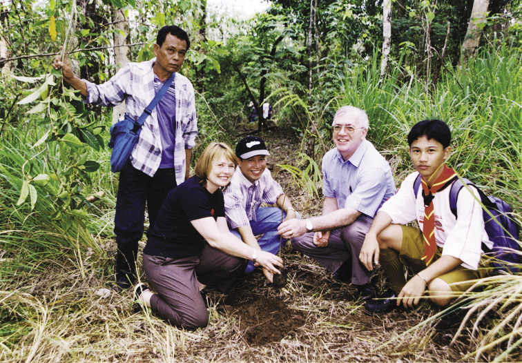 The Australian Ambassador to the Philippines, Ruth Pearce (second left), the Executive Director of the Bantay Kalkasan (Environment Watch), Marol Mendoza (centre), and the UN Resident Coordinator, Terence Jones (second right), watched by Bantay Kalikasan engineer, Willy Martin (left) and Boy Scout, Michael Erwin Encarnacion, lead a tree planting activity to rehabilitate and reforest the La Mesa Watershed, Quezon City, World Environment Day, 5 June 2002. [Department of Foreign Affairs and Trade]