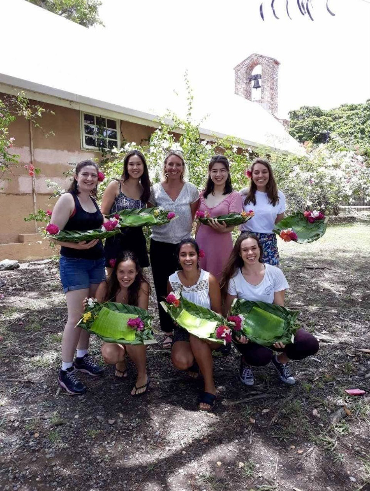 Group of 8 women holding native woven baskets 