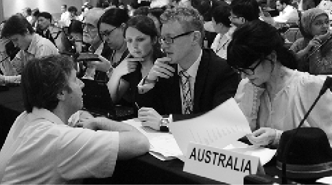 Australian delegate, Andrew Ure (second right), speaks with European Commission negotiator, Martin Weiss (front), at the Conference of the Parties (COP 16) to the UN Framework Convention on Climate Change, Cancún, 29 November to 10 December 2010. Seated right is the Australian Ambassador for Climate Change, Louise Hand. [IISD/Earth Negotiations Bulletin]