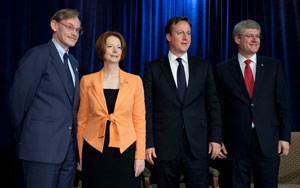 Prime Minister Gillard standing on a stage with the Canadian and UK Prime Ministers and the President of the World Bank.