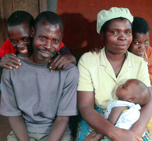 Photo of a mother and father surrounded by 3 of their children.