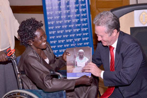 A woman in a wheelchair presenting a man with an award