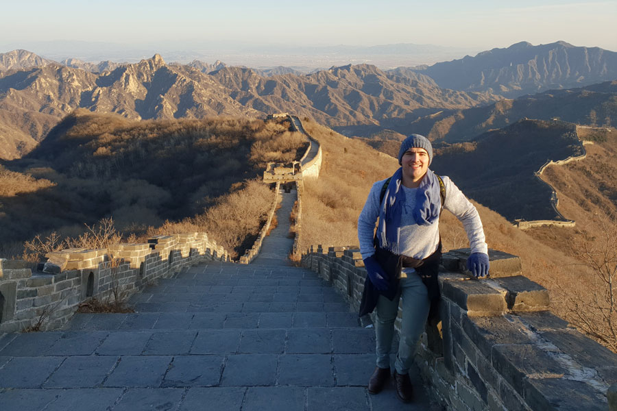 Photo of Mitchell Francis climbing the Great Wall of China.