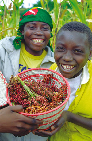 two young women smiling and holding a bowl of food