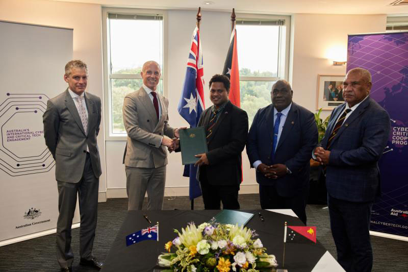 Image of Dr Tobias Feakin and Mr Steven Matainaho shaking hands after signing the MOU on Cyber Cooperation.