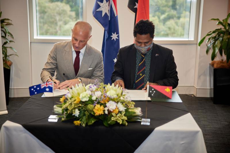 Image of Dr Tobias Feakin and Mr Steven Matainaho signing the MOU on Cyber Cooperation.