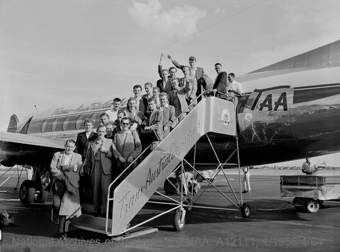 Group photo of people disembarking a plane on a stair case.