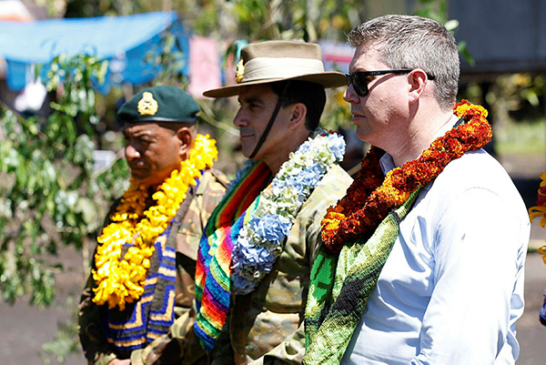 Two soliders and a man standing in line