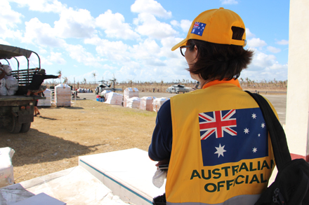 Australian Official observiing a truck delivering humanitarian relief in Guiuan