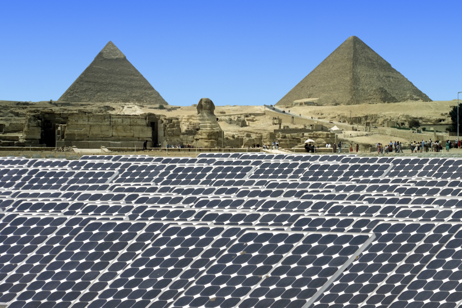 Large solar power plant with Egyptian pyramids in the distance