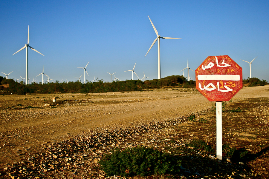 View of wind power turbines along an unsealed road in Morocco