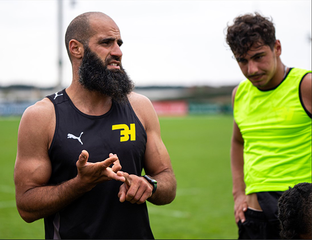 Two men in sporting gear standing on an oval