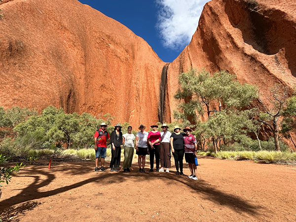 Senior Cook Islands officials standing in a line in front of a rocky red landscape at Uluru, Northern Territory