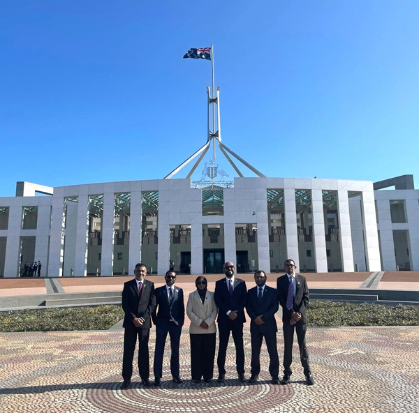 Six people standing in the forecourt of Parliament House, Canberra