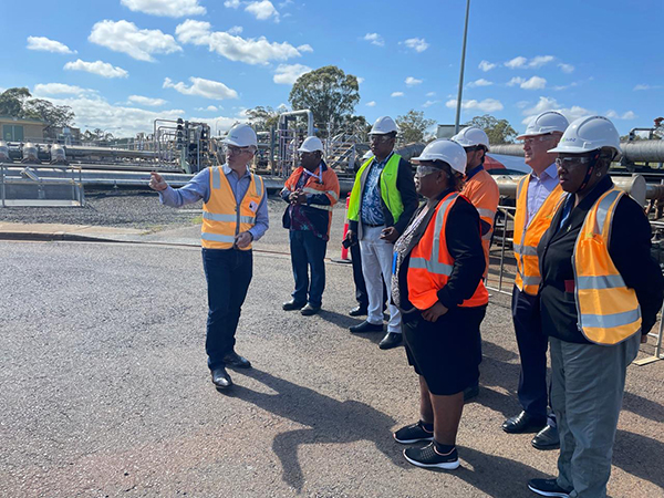 Senior Solomon Islands officials wearing safety vests and hard hats, on a site visit at the Port of Brisbane, Queensland led by a Port of Brisbane official.