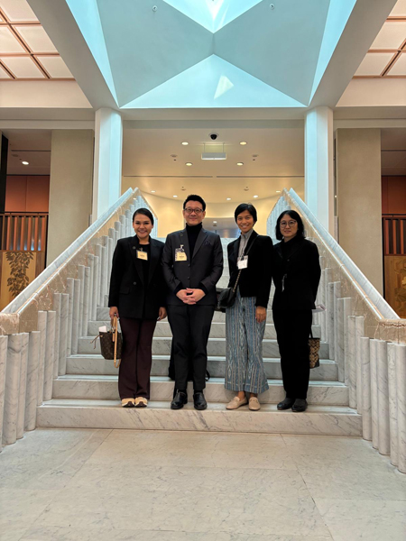 four people standing together on a staircase inside Parliament House