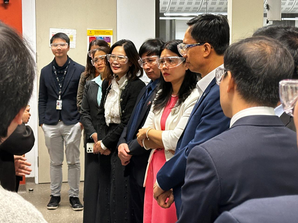 People standing together in business attire, wearing safety glasses