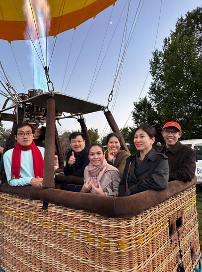 A group of people in a hot air balloon basket ready to take off.