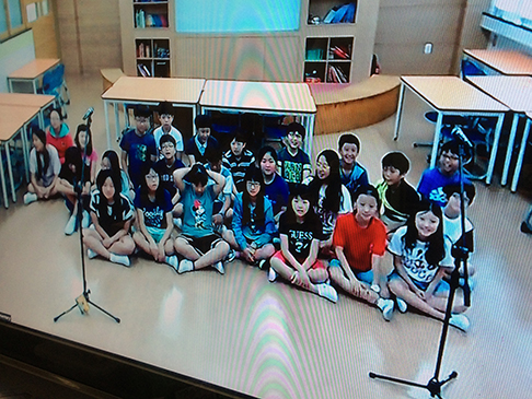 Group of young students sitting on the floor in a classroom