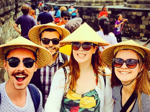 Four people smiling with the temple behind them