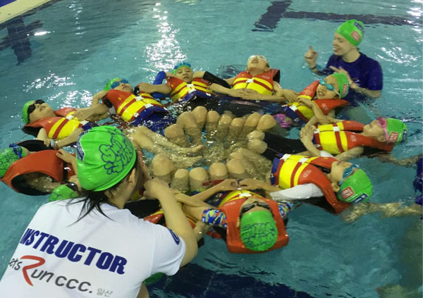 School children in a pool with instructors