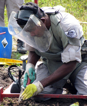 A de-miner manually clearing the land of mines.