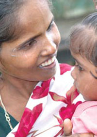 Photo of a smiling woman holding a child