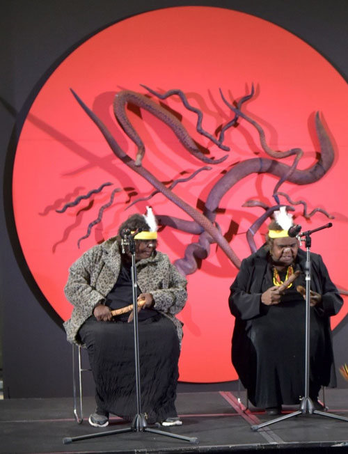 Elders Ms Yaritji Heffernan and Ms Inawinytji Williamson sing Seven Sisters on stage with clap sticks.