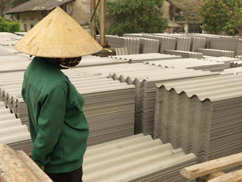 Vietnamese workers loading asbestos roof sheet