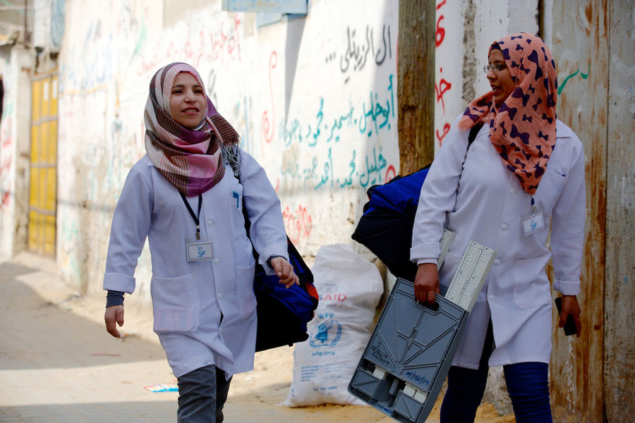 Two women walking in a street.