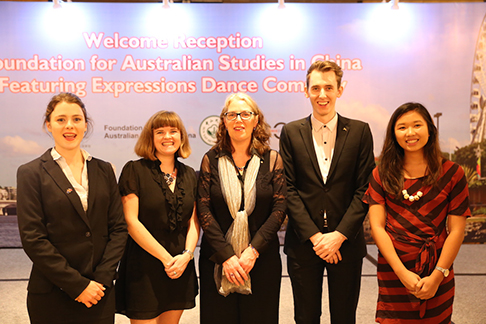 Group of five people standing in front of a Welcome Reception: Foundation for Australian Studies in China, Featuring Expressions Dance Company sign