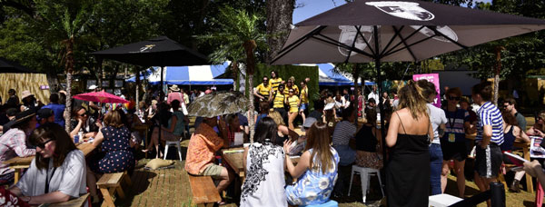 Many people gathered around tables outside