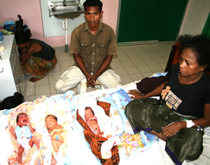 A mother and father with newborn triplets