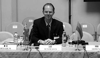 Photo of Mr Bayer sitting at a conference desk.