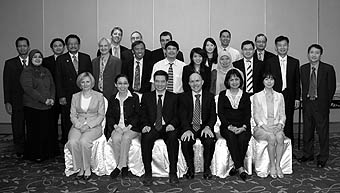 Photo of assembled conference participants sitting and standing in three rows.