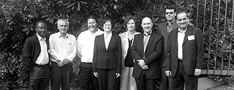 Photo of 8 inspectors and representatives in suits standing in a line.