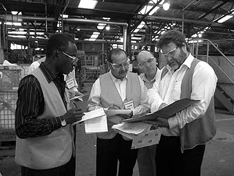 Photo of 5 representatives wearing visibility jackets in a warehouse.