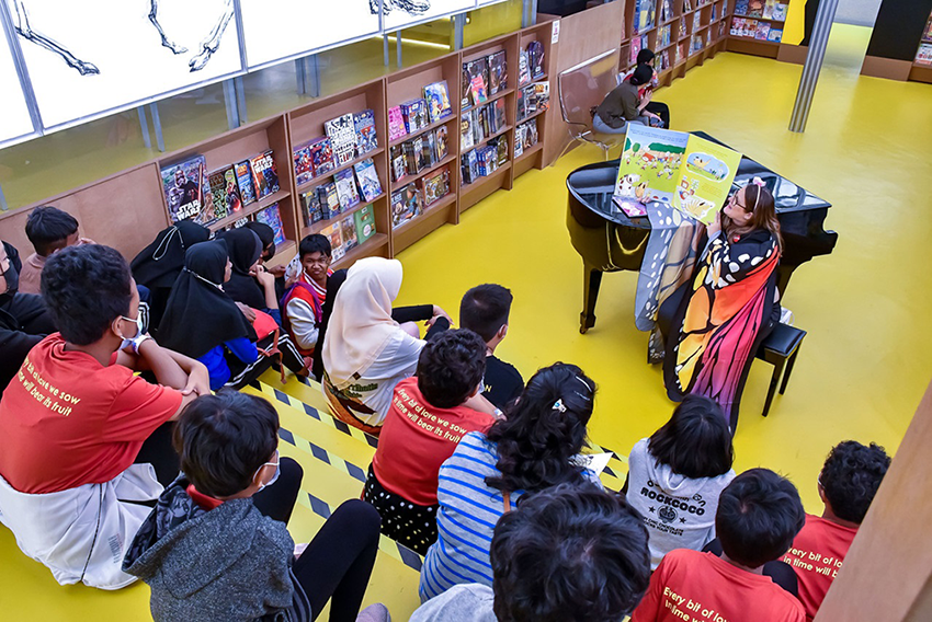 Jessica reading to children at an event with fashion designer Melinda Looi at BookXcess. 