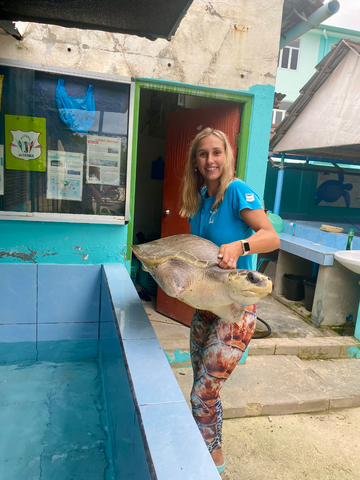 Image of women carrying amputee rescued turtle. 