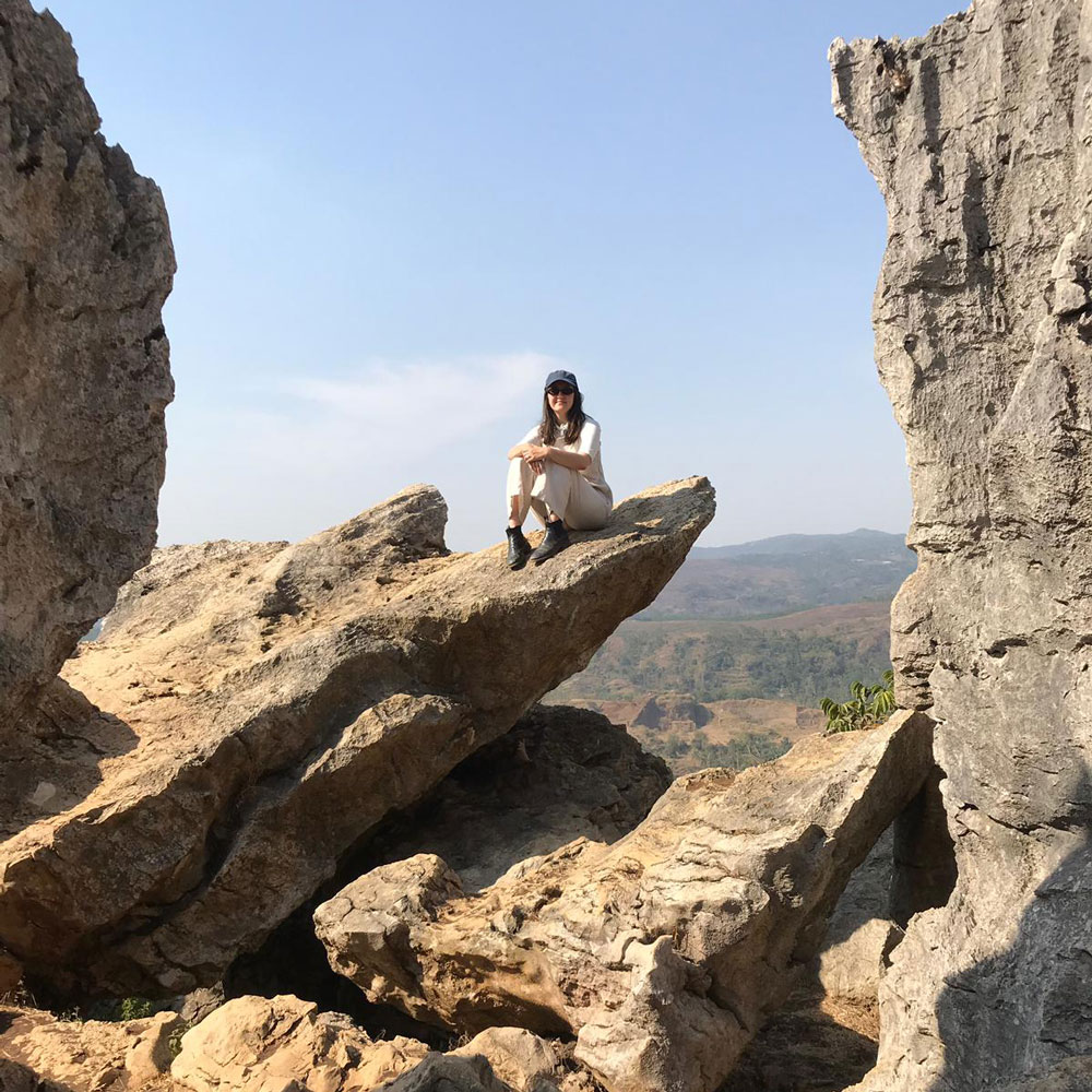 Photo of Madeline sitting on a rock at the Stone Garden in West Java.