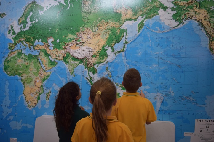 children stood in front of a map