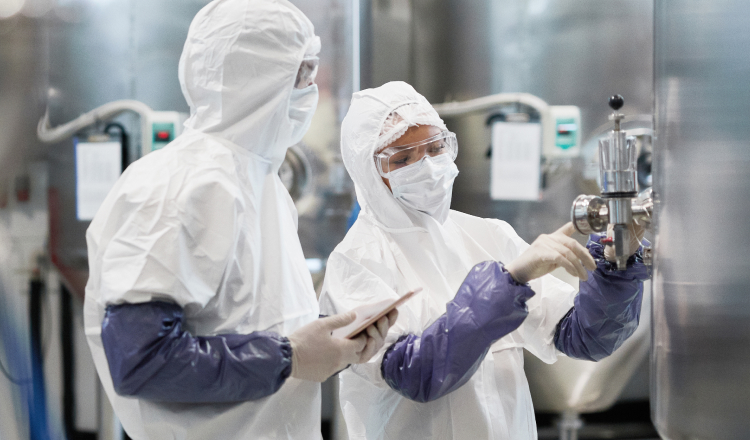 Two workers controlling pharmaceutical production