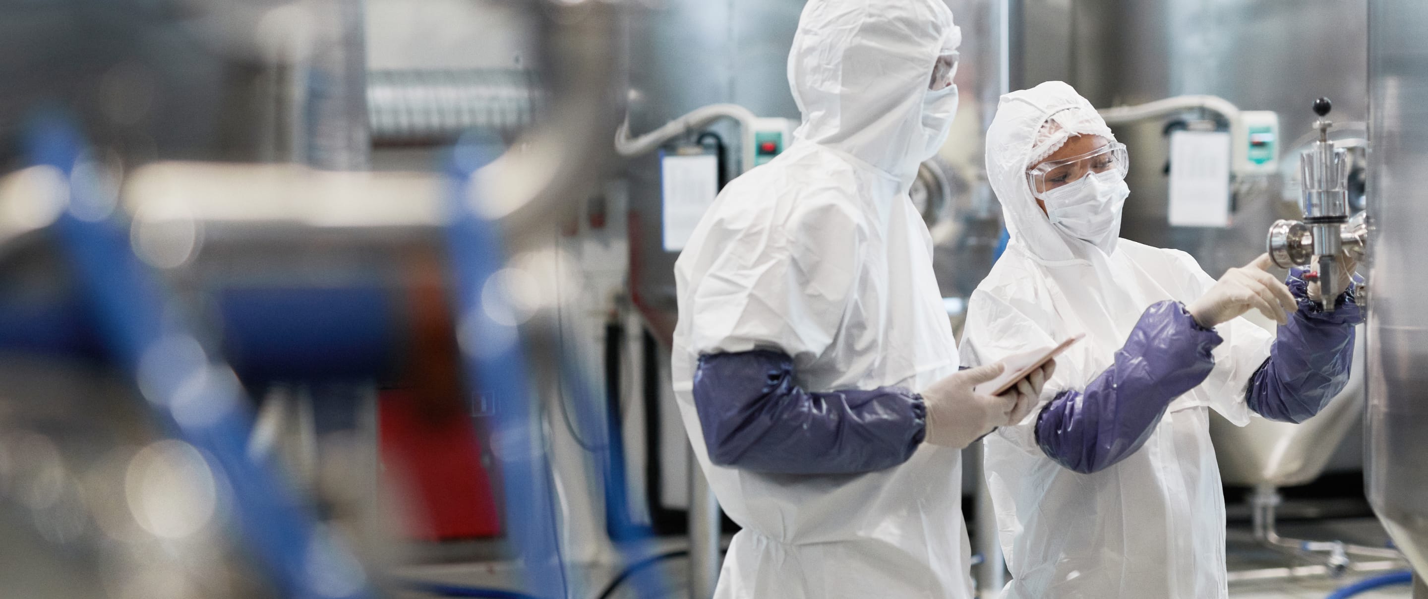 Two workers controlling pharmaceutical production