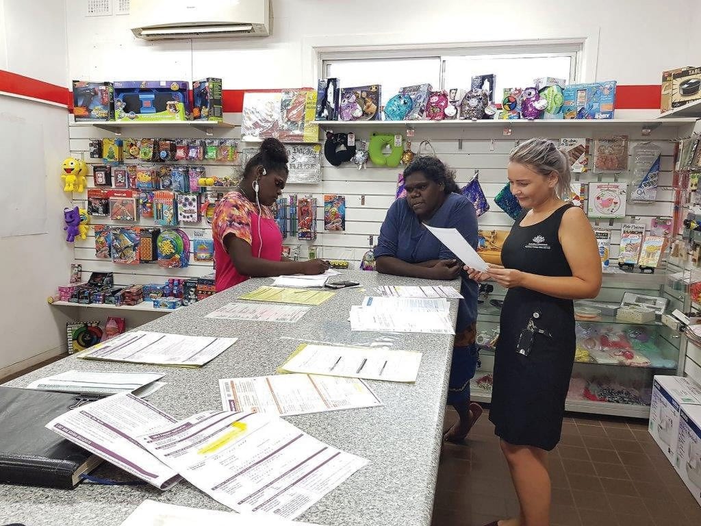 Passport officer Ashlee Sevior assisting passport applicant Chinelle Bara and her mother Mary-Jane Bara at Alyangula post office [Northern Territory Police Fire and Emergency Services/Debra Blackwell]