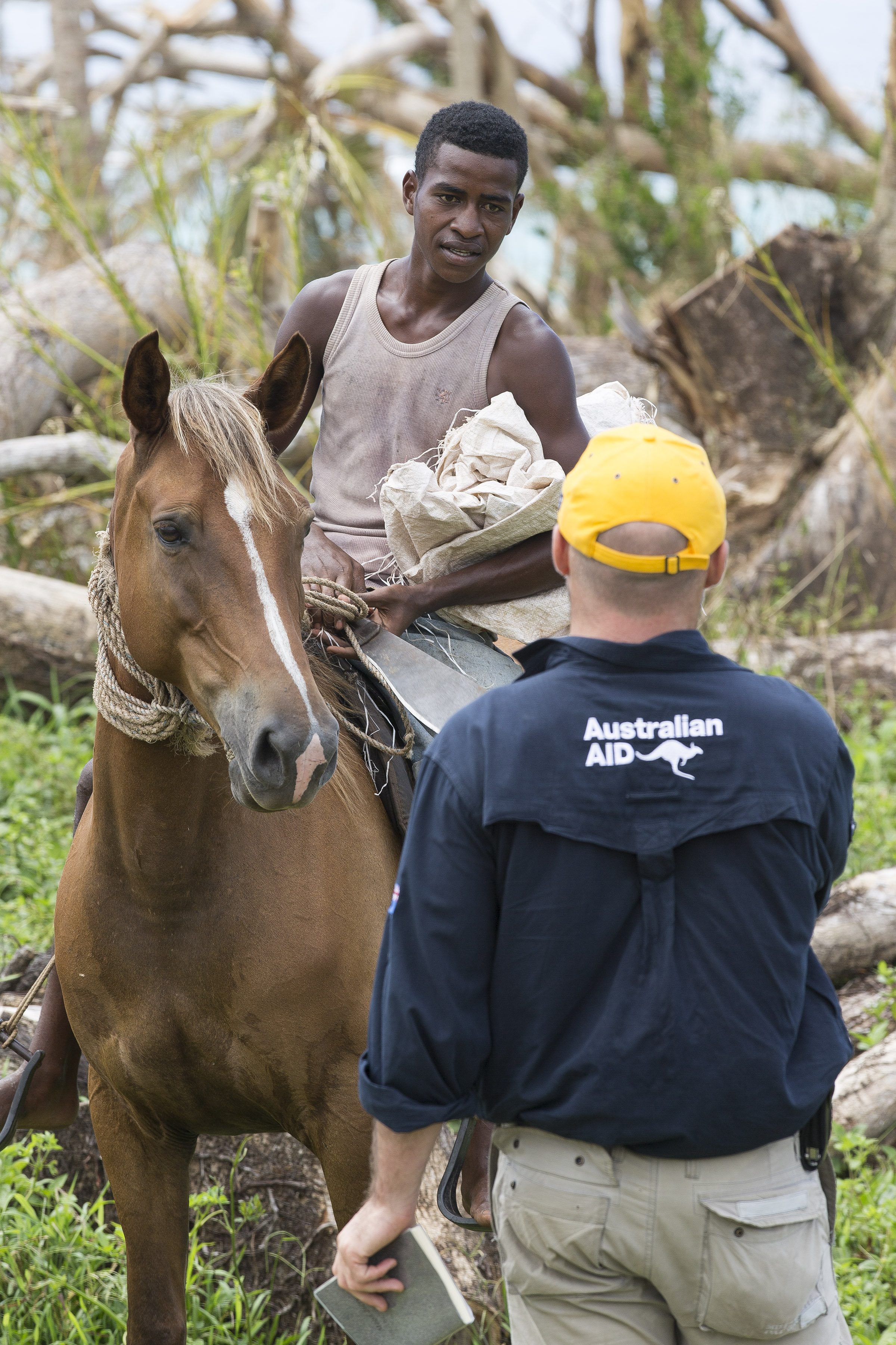 In support of Operation Fiji Assist, a member of the Australian Government Department of Foreign Affairs and Trade Brek Batley, speaks with a local villager about the effects of Tropical Cyclone Winston on Koro Island, Fiji. *** Local Caption *** On Friday 26 February 2016, Department of Foreign Affairs and Trade (DFAT), Australian Defence Force (ADF) and Republic of Fiji Military Forces (RFMF) personnel, delivered 2.2 tonnes of aid to Fiji's Koro Island-one of the worst struck by Tropical Cyclone Winston. The emergency relief stores were inserted by the Australian Army Taipan MRH-90 helicopter, designed to carry heavy loads of stores into areas otherwise inaccessible. One week on from the cyclone, remote communities are in need of immediate relief. The MRH-90 will provide critical capability in providing support as part of the Australian Whole of Government response to the Fiji Government's request for Humanitarian Aid and Disaster Relief (HADR).