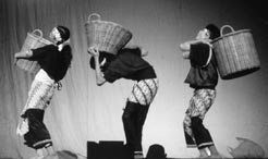 Three people on stage carrying baskets