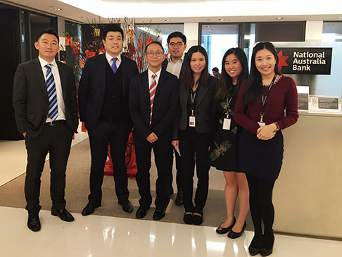 Seven people standing in front of National Australia Bank sign