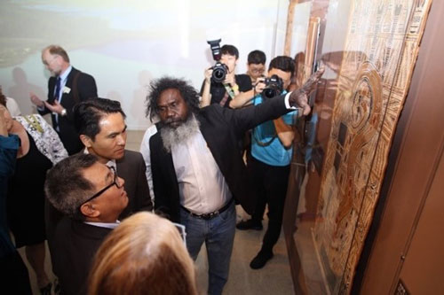 Artist Witiyana Marika show his ancestors’ bark paintings to Wang Chunfa and other spectators.